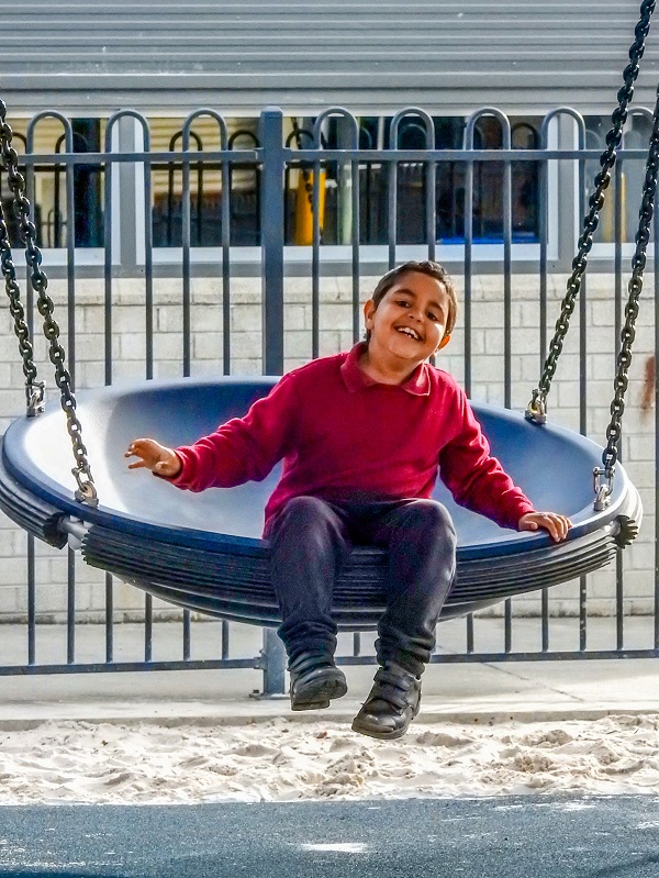 Child playing on a swing at East Gippsland Specialist School Playground