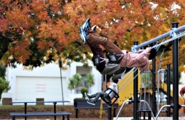 Child playing on a swing at Irving Street Playground three-bay-swing