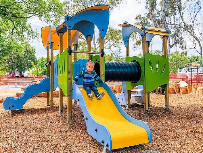 Child playing on a slide at Edinburgh Gardens Playground