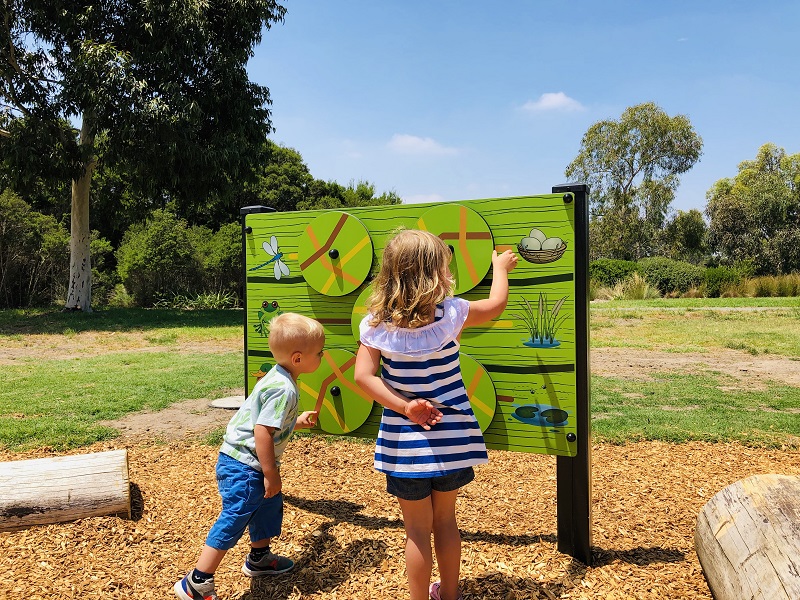 Child playing with a play panel at Pencil Park Playground at Hidden Grove Reserve