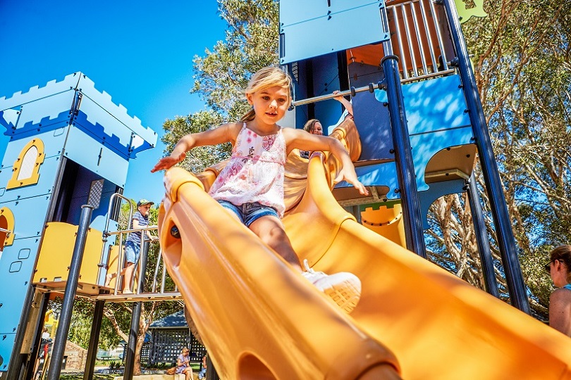 Child playing on a slide at Tugun Park castle themed playground