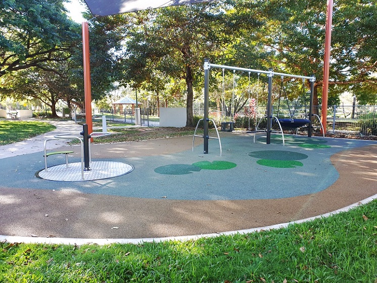 Carousel and swing set at Aplins Weir Rotary Park inclusive playground
