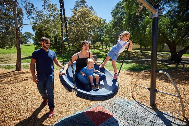 Child playing on a swing Austin Crescent Reserve playspace