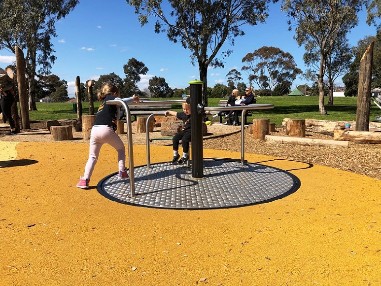 Child playing on a carousel at Elsternwick Park Playground
