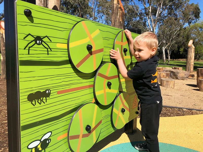 Child playing with play panel at Elsternwick Park Playground