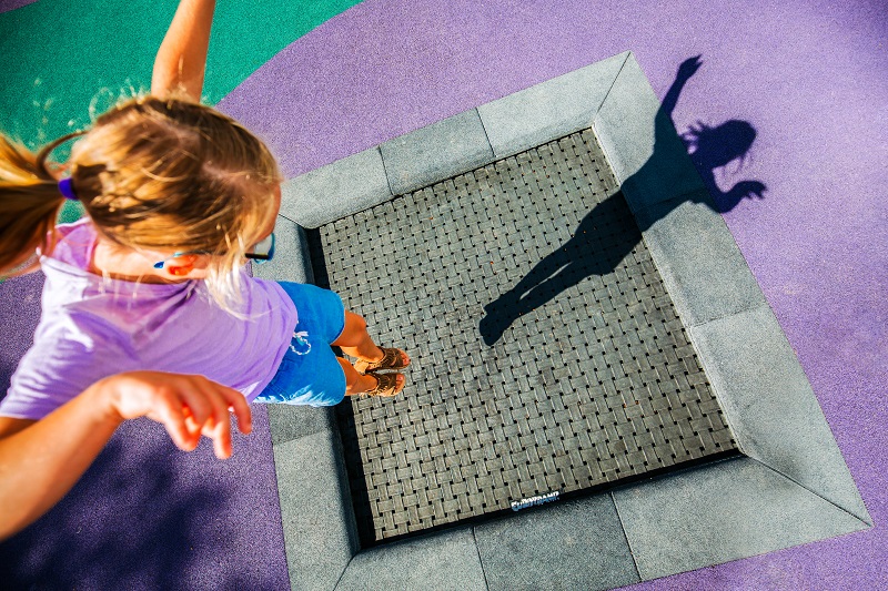 Child playing on a trampoline at Wolseley Park Inclusive Playground