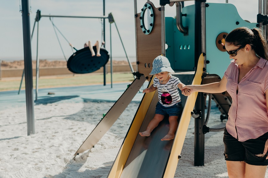 Child playing on a slide at Cemetery Beach Park Playspace