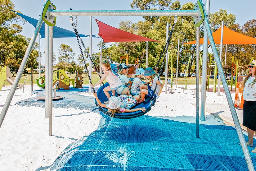 Children in a pod swing at Queens Garden Playground