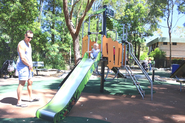 child playing on a slide at Frank Beckman Playground