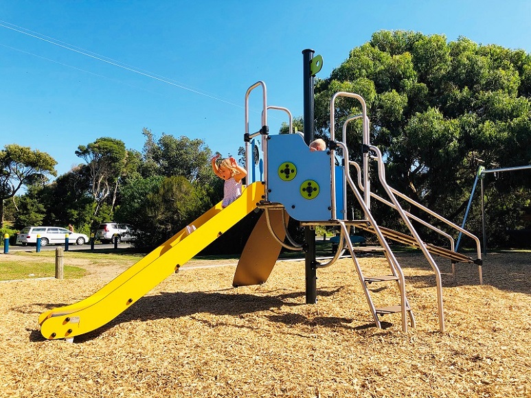 Child pl;aing on a slide at Gale St Reserve Playground