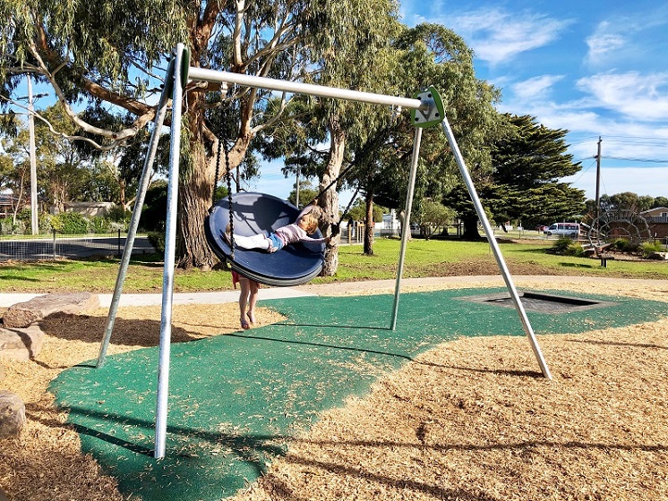 Chils playing on a swing at Harold Hughes Reserve Playground