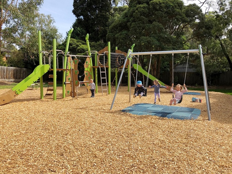 Child playing on a swing at Naughton Patch Playspace