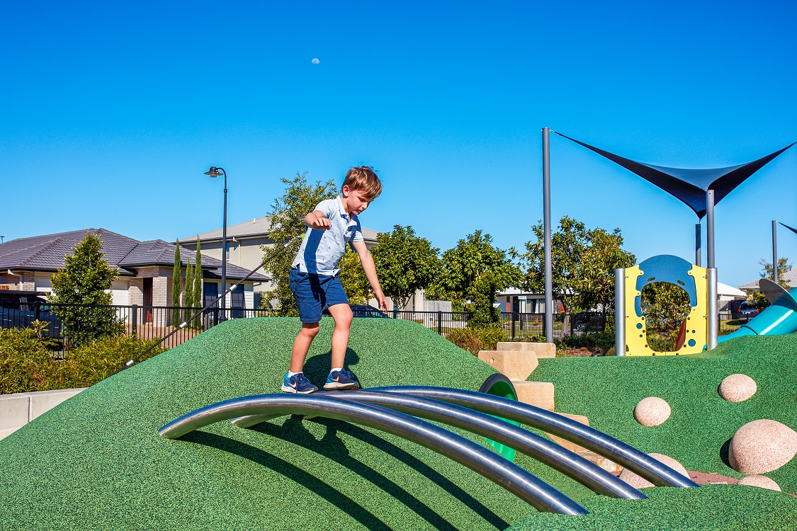 Child playing at Stainless steel mound tube rails