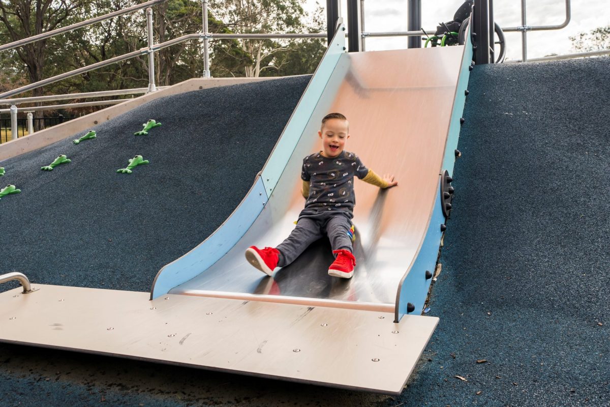 Boy with Down Syndrome on slide