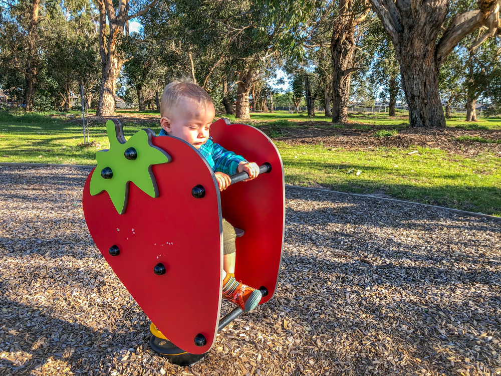 Child on strawberry springer at Walnut Way Playground