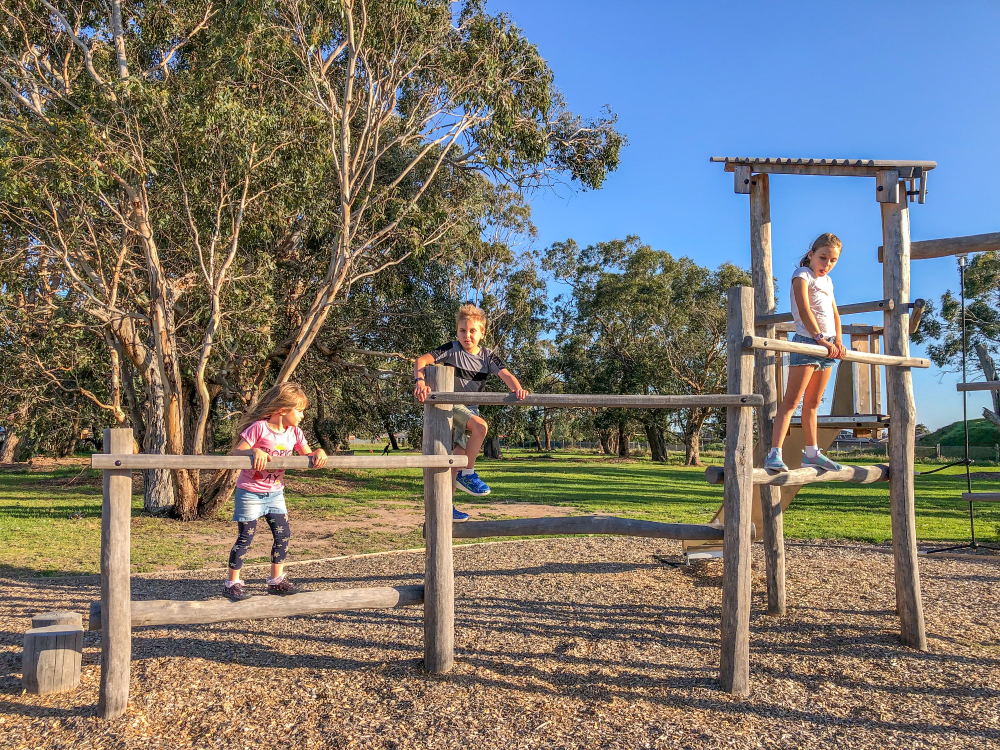 Children playing on Origin' Balancing Trail at Walnut Way Reserve Playground