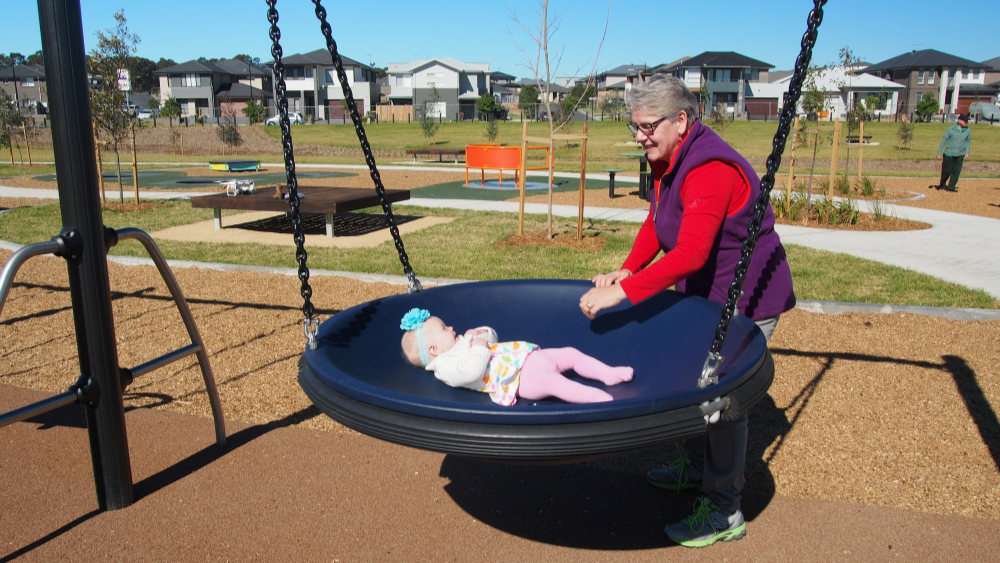 Grandmother and grandchild using a pod swing and bond