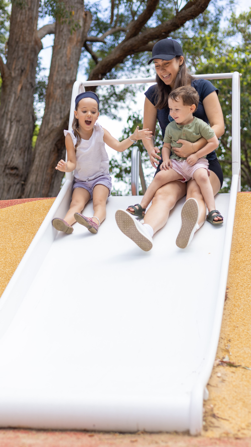 Carer with children on slide