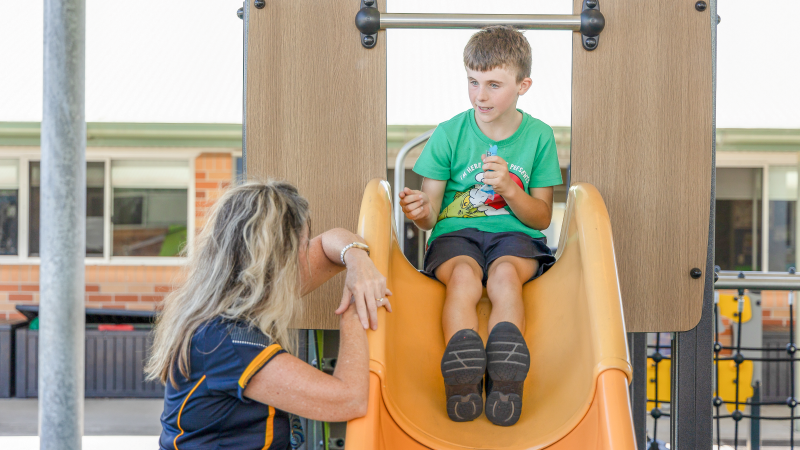 Child interacting with carer while being on a slide