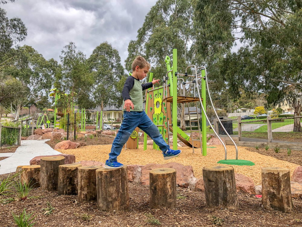 Child walking over stepping logs
