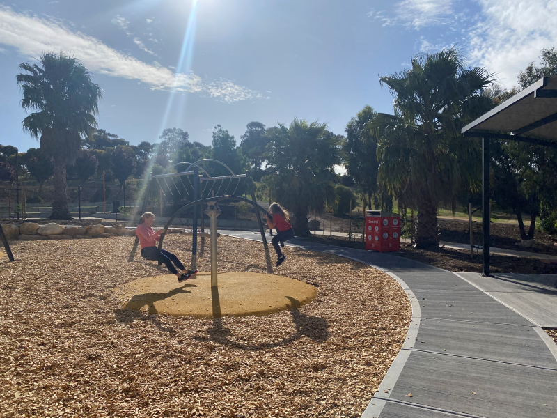 Child and Carer playing on Hip Hop play equipment