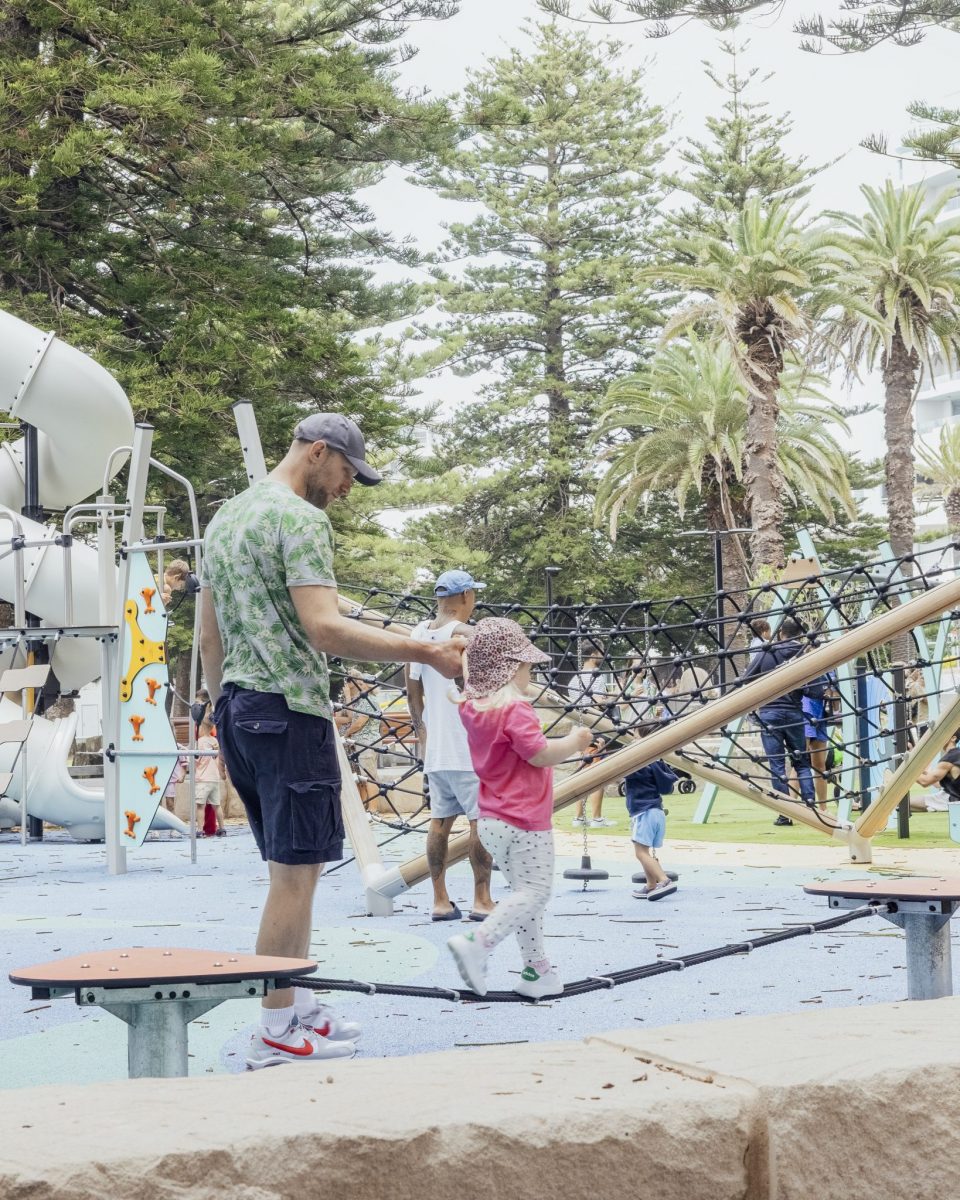 Parent helping child balancing on a slackline