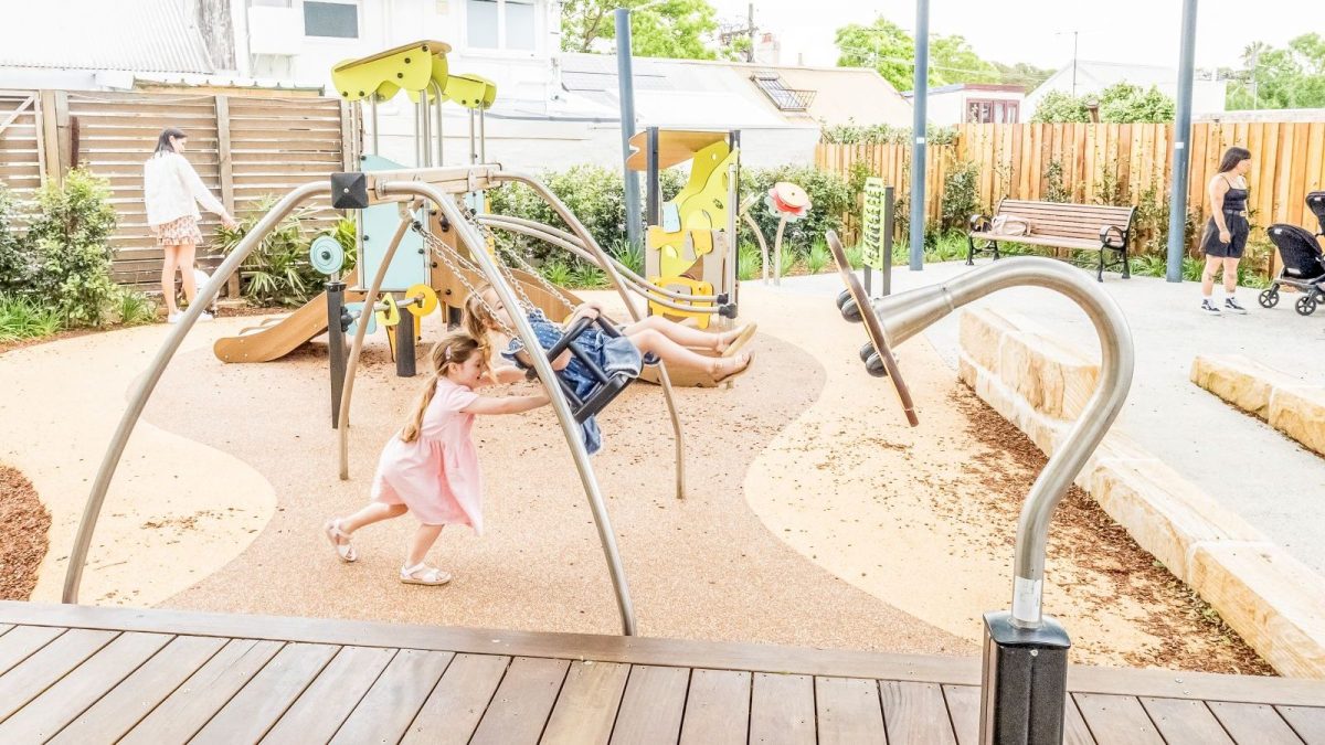 Twins playing with the little swing at Spring Street Reserve Toddler Playground